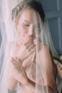 Kız ikindilerde beyaz bir örtü ile kaplı bir sandalyede oturuyor.