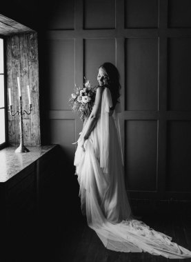 pencere ellerinde çiçeklerle yakınındaki giysi beyaz düğün gelin