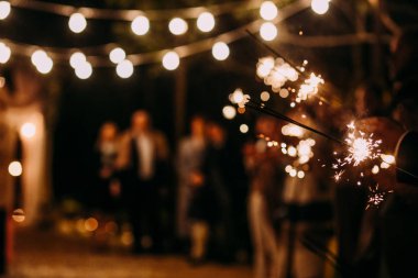 Bengal ışıkları ve insanlar içinde belgili tanımlık geçmiş ile gece bir partide retro ampul