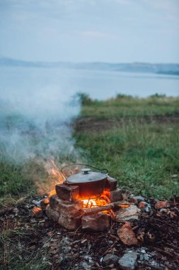 Balık ve vahşi bir piknik ateşe dekorasyonu ile yulaf lapası yemek
