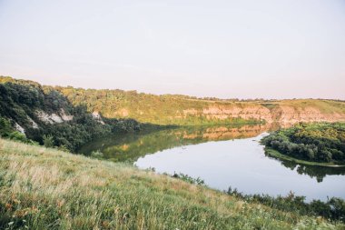 kayalar ve kanyonlar ve çiy ile şafak yeşil bitki örtüsü dolambaçlı bir kanal ile manzara