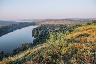 kayalar ve kanyonlar ve çiy ile şafak yeşil bitki örtüsü dolambaçlı bir kanal ile manzara