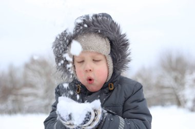 sıcak ceketli çocuk aktif kar ile çalış ve sevinir