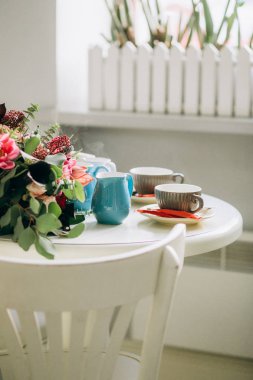 bir kafede beyaz masa kahve ve tatlı iki kisilik dışarı atılır