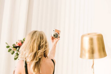 uzun saç ve çiçekler ile kız kendini bir kaset kamera ile fotoğraf çeker