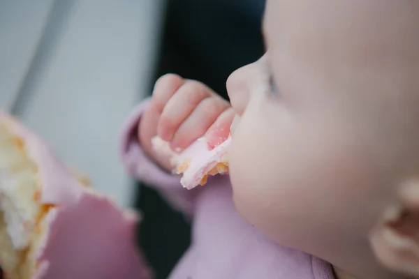 子は彼の手でピンクのケーキのスライスを食べるし 窓の外に見える — ストック写真