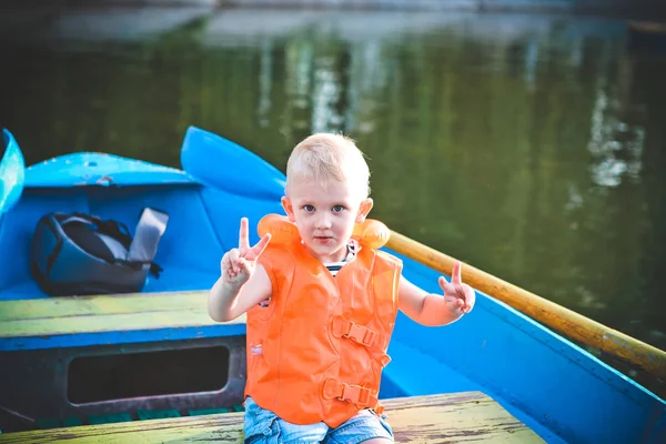 感情や不安にボートでオレンジ色のライフ ジャケットで一人の子供 — ストック写真