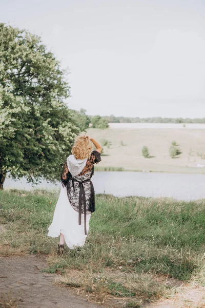 country blonde woman backs dress field river