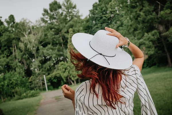 girl red haired summer light clothes hat  movement