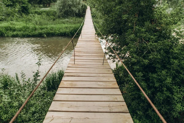 Puente de cable suspendido sobre el suelo de madera del río — Foto de Stock