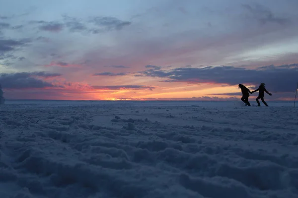 커플 사랑 실행 눈 덮인 얼음 호수 실루엣 — 스톡 사진