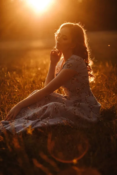 Девушка в луговом парке закат оранжевые лучи — стоковое фото