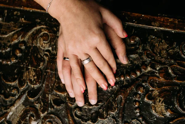 Mãos casal anéis de casamento esculpido fundo textura — Fotografia de Stock