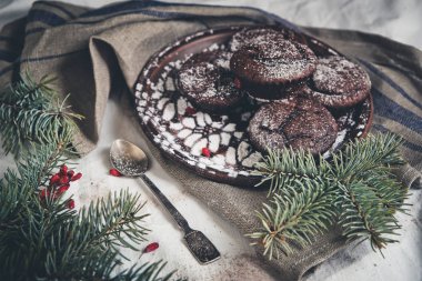 çikolatalı muffin serpilir pudra şekeri kozalaklı dallar