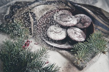 çikolatalı muffin serpilir pudra şekeri kozalaklı dallar