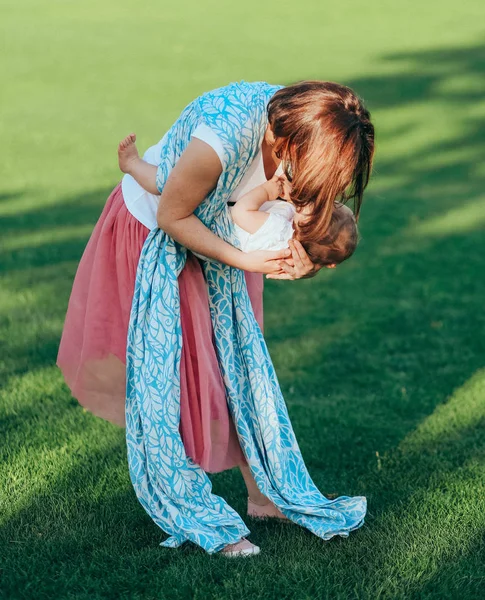 Woman small infant plays outside park meadow — Stock Photo, Image