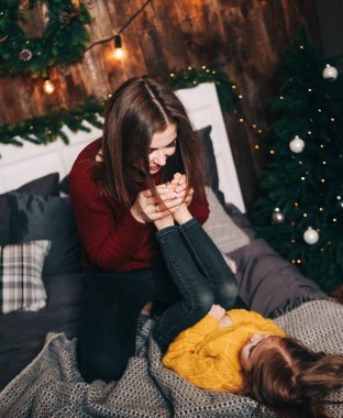 Anne kızı Noel süslemeleri içinde eğleniyor.