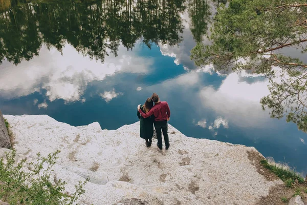 Dışarıda sevgi dolu bir çift göl kanyonu gün batımına sarılıyor. — Stok fotoğraf