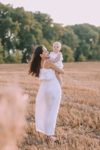 Mor liten dotter vita klänningar fält halm — Stockfoto