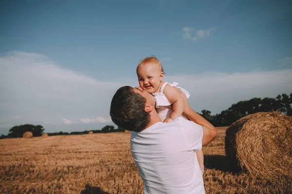 Far dotter glädje spel kasta upp baby fält — Stockfoto