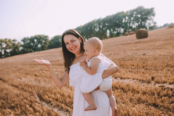 Mor liten dotter vita klänningar fält halm — Stockfoto