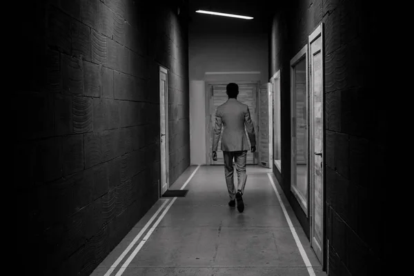 Homem bem sucedido caminha corredor abaixo escolhe porta — Fotografia de Stock