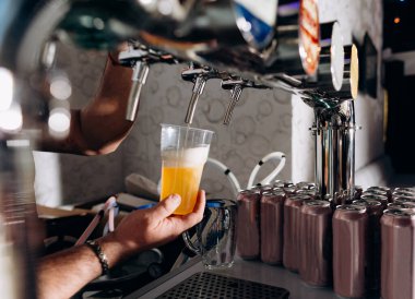 Barmen barın her çeşidinde bardağa bira doldurur.