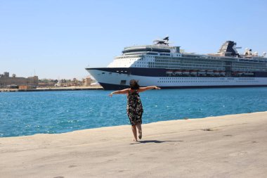 Limandaki yetişkin kadın, turist yolcu gemisinden memnun olan akrabalarıyla tanışıyor.