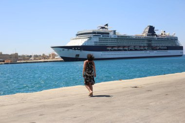 Limandaki yetişkin kadın, turist yolcu gemisinden memnun olan akrabalarıyla tanışıyor.