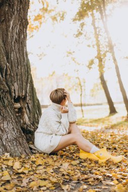 Sonbahar sarı yaprağı parka düştü kavramsal kız.