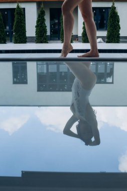 Mayolu bir kız, su havuzunda güneş yanığının tadını çıkarıyor.