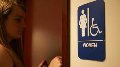 Kadın bir banyo kapısını girmeden önce kapıyı çalar