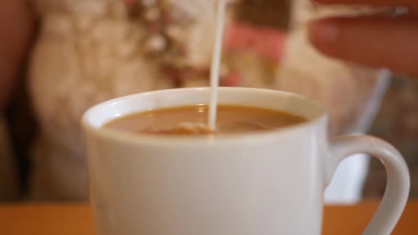 女人把奶油放进咖啡里 用勺子搅拌 — 图库视频影像