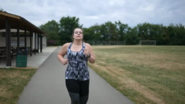 ジョギングの女性が公園で実行中に腰痛を経験します — ストック動画