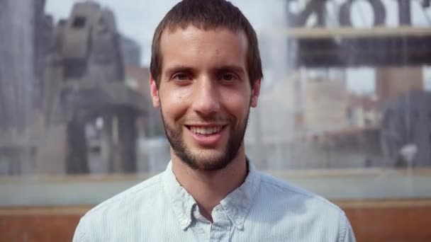 Guapo Hombre Caucásico Sonríe Cámara Detrás Fuente Agua Gran Ciudad — Vídeos de Stock