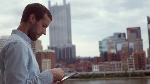 Mann Benutzt Tablet Innenstadt Mit Kino Wolkenkratzern — Stockvideo