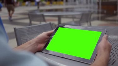 Bir adam bir yeşil ekran tablet su özellikleri yakın şehir merkezinde iş alanda saatler