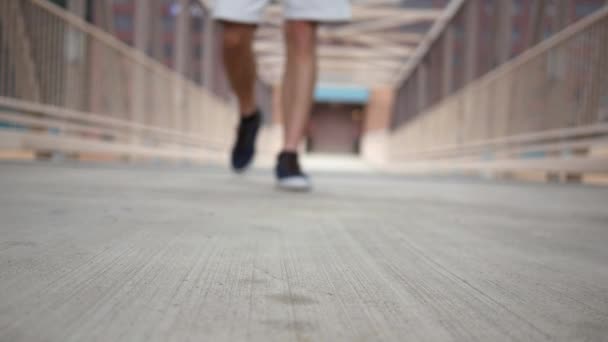 若い男は青い靴を履いてカメラに向かって歩く — ストック動画