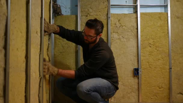 Een Huiseigenaar Duwt Isolatie Muur Van Onvoltooide Kelder — Stockvideo