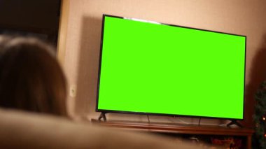 Kadın oturma odasında bir yeşil ekran 4 k televizyon izleyen
