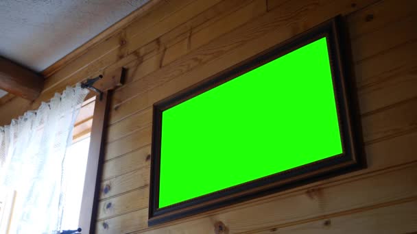 Un cadre photo écran vert accroché au mur de la cabane en rondins ou à l'intérieur de la maison de campagne 