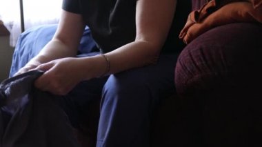 Orta yaşlı Kadın oturma odasında çamaşır katlayarak - 3 2 vurdu