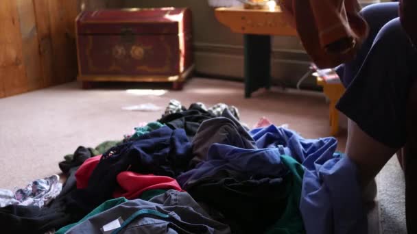 中年女性はリビングルームで洗濯物を折る の1のショット — ストック動画