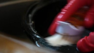 Lavaboda bir güveç tencere yıkamak için bir ovma fırçası kullanma - yakın açı