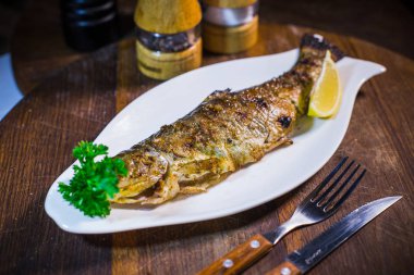 Limon ve beyaz tabakta maydanoz fırında uskumru