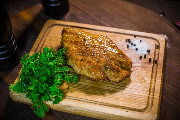 Grilled chicken fillet, served on a plate of wood. — Stock Photo, Image