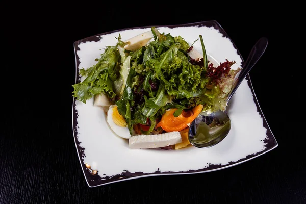Salat mit Ei, Paprika, Käse und Tomaten auf einem Teller serviert. — Stockfoto