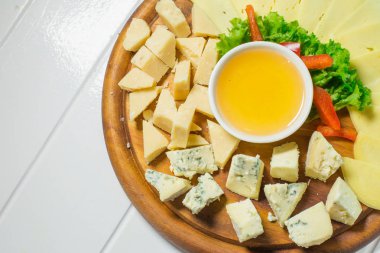 Peynir tabağı farklı peynir, bal ve sebze ile