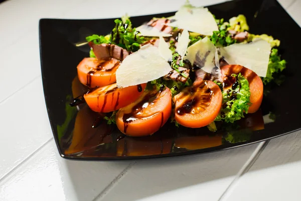 Салат из телятины с рукколой, салатом, помидорами, оливками и сыром пармезан — стоковое фото