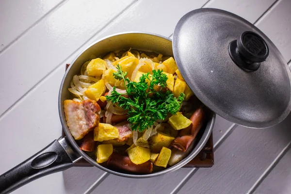Жареное яйцо с колбасой и картошкой в сковородке — стоковое фото
